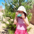 Little girl taking a photo with her Montessori Wooden Camera.