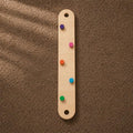 Wooden beam with colorful pegs for balance practice.


