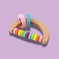 Semi-circle wooden rattle toy from the Montessori Rattle Kit. 