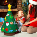 Baby and his mother next to a 360 Montessori Christmas Tree in a holiday set up. 