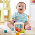 Baby sitting and enjoying the Montessori Shape Blocks toy.