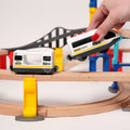 Child connecting a magnetic toy train engine to a passenger car on a Montessori Crane and Train Magnetic Playset.