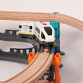 Battery-powered toy train with glowing headlights traveling between elevated wooden tracks on a multilevel train set.