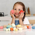 A girl smiling and holding her Montessori Wooden Stones