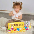 Toddler girl sitting and playing with Montessori Geometric Eggs.