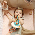 Little baby girl in her crib chewing on the Montessori Silicone Pulling Toy