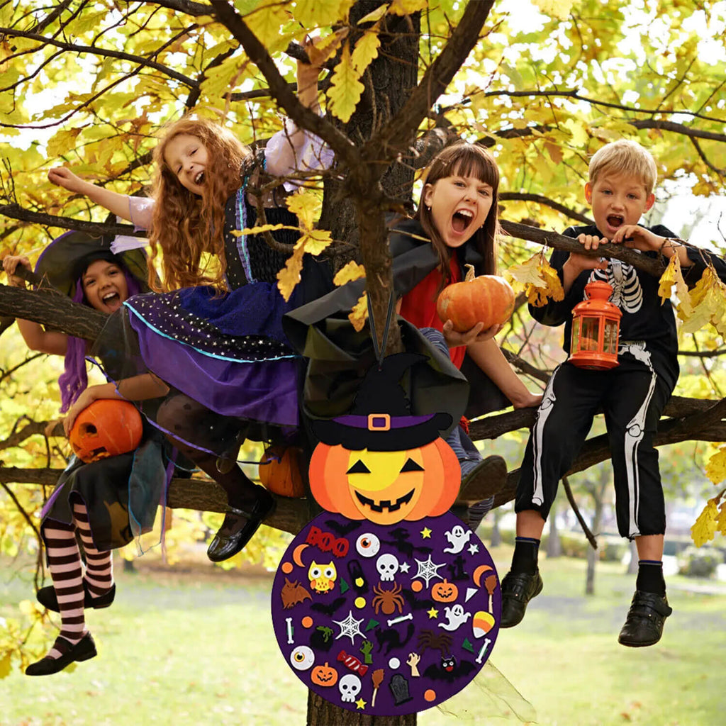 Children sitting a tree in Halloween costumes and the Montessori Halloween Pumpkin hanging underneath them.