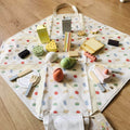 Fully set up Montessori Picnic set with a bag and wooden food, fruits, and cakes.