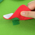 A hand showing how to attach ornaments on the Montessori Christmas Tree with velcro.