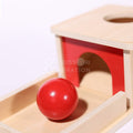Close-up of red wooden ball that is a part of Object Permanence Box made for toddlers.