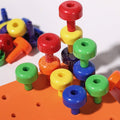 Closeup of the stacked peg pieces that belong to the Montessori pegboard set.