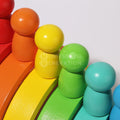 Closeup of orange, yellow, green, and blue Montessori rainbow figurines.
